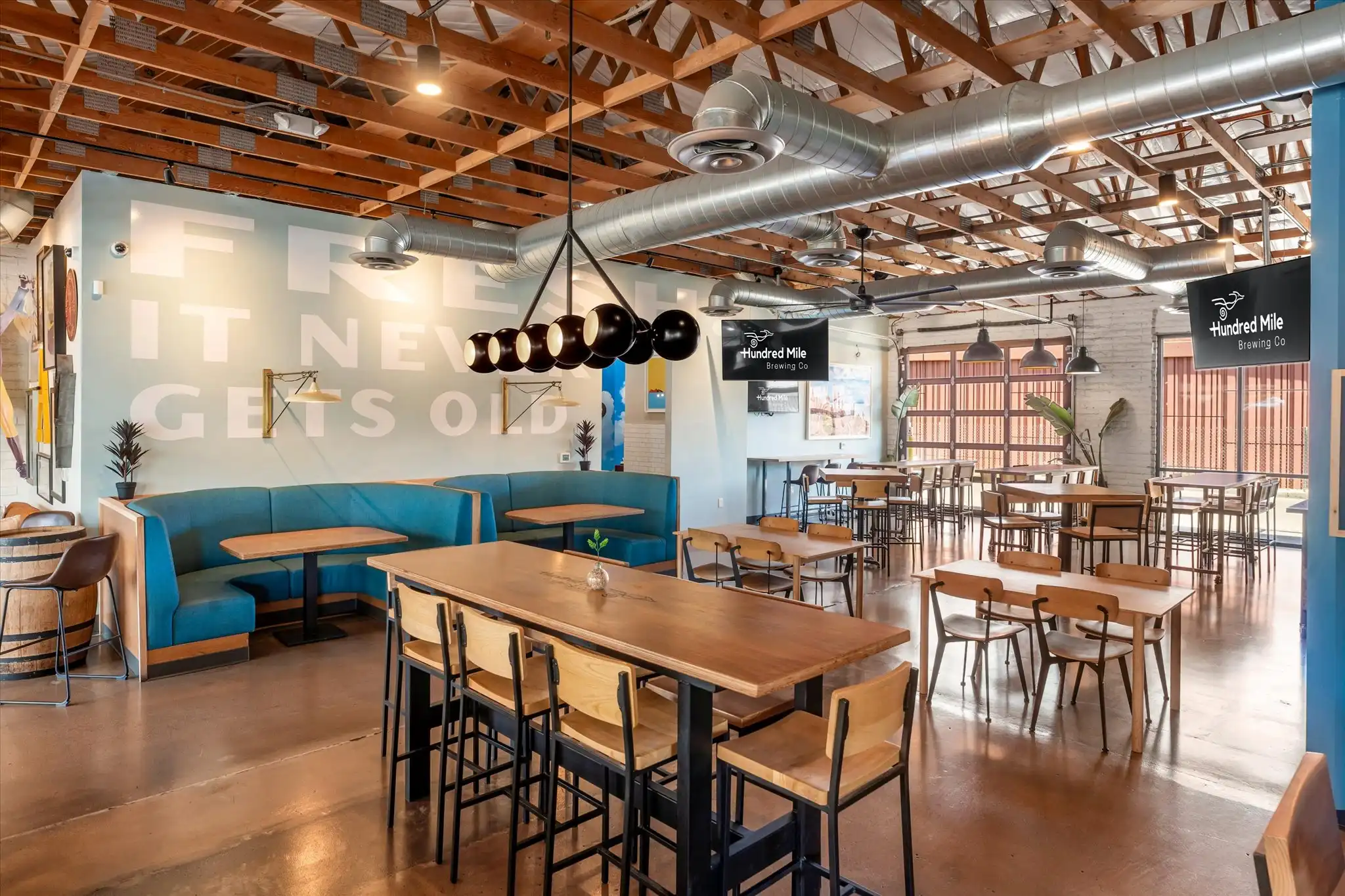 Coyote Cove set with tables, string lights, and wall-mounted TVs.