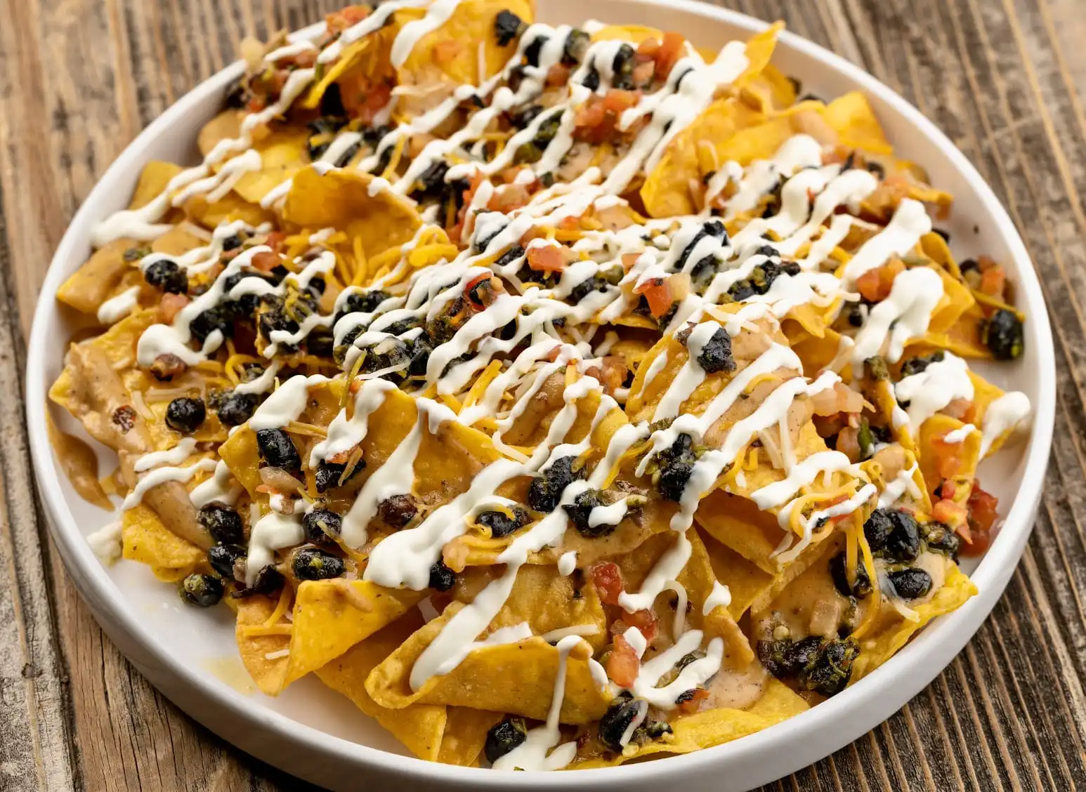 Loaded nachos topped with beef, melted cheese, pico de gallo, and crema.