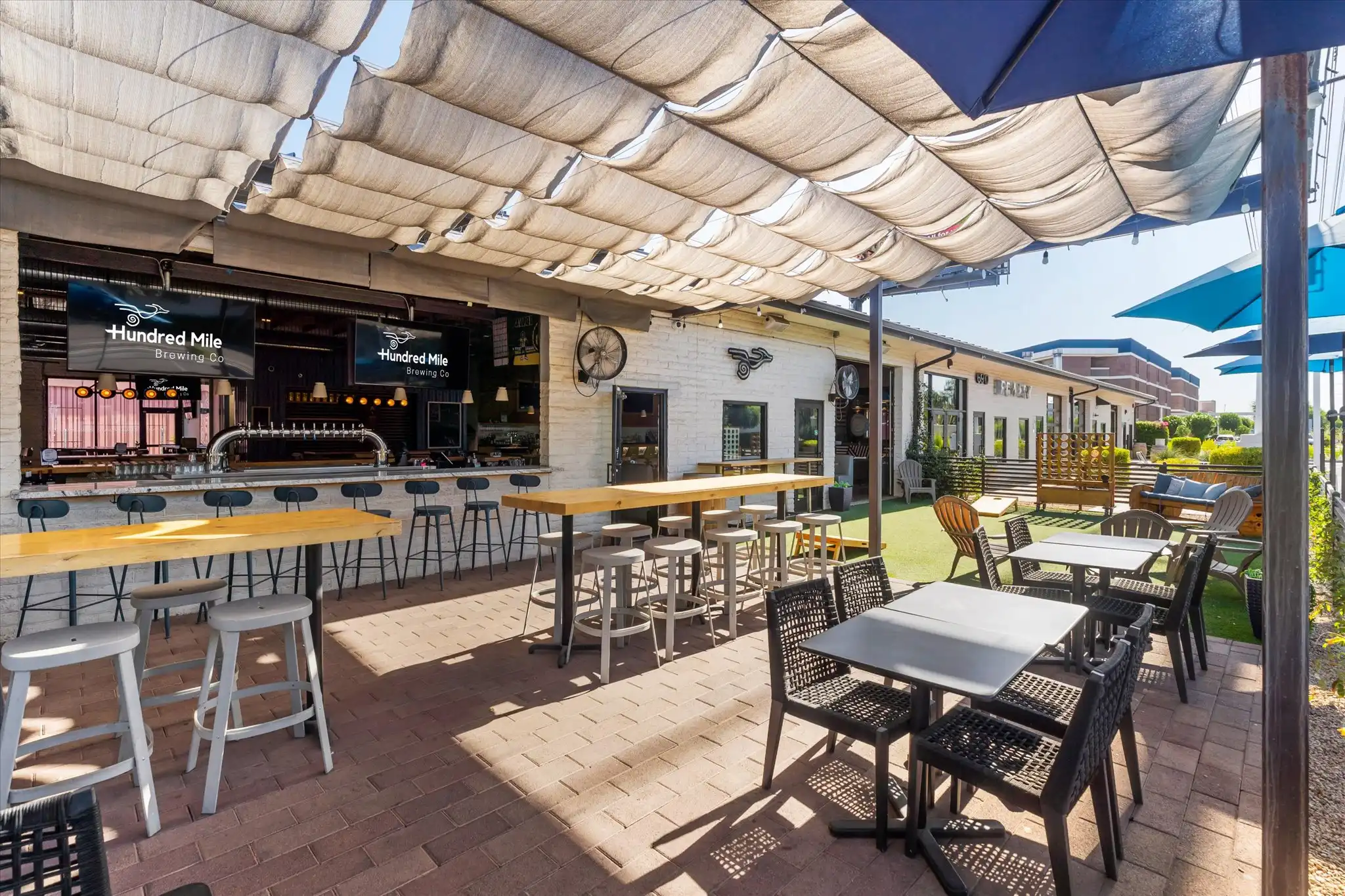 Covered patio bar with a roll-up door, a television, and bar seating.